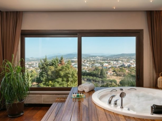 Stylish bathroom featuring city views and a hot tub.
