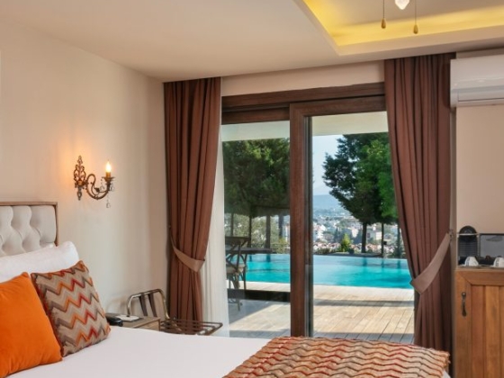 Elegant bedroom features a large window overlooking a pool.