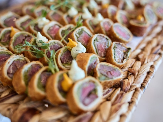 Delicious bite-sized beef rolls on a woven tray.