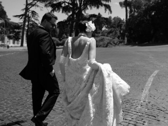 A couple walks together, the bride in a beautiful gown.