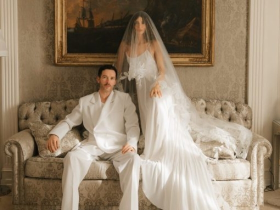 A stylish couple poses on a sofa in a beautifully decorated room.