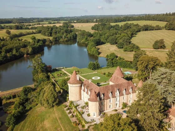 Beautiful castle surrounded by lush greenery and a serene lake.