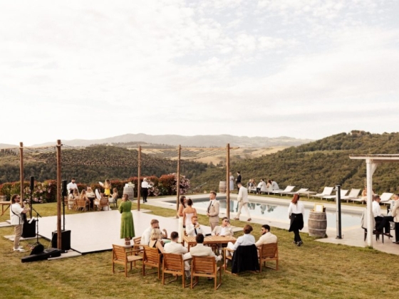 Guests enjoying a gathering near a pool with mountains in the background.