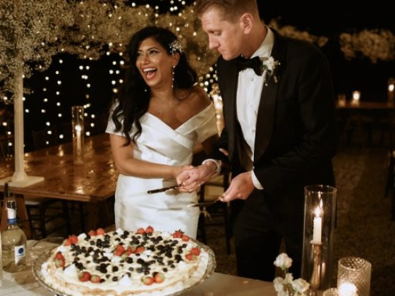 Bride and groom joyfully cut their wedding cake.