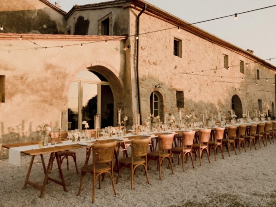 Long table decorated for an outdoor event in golden light.