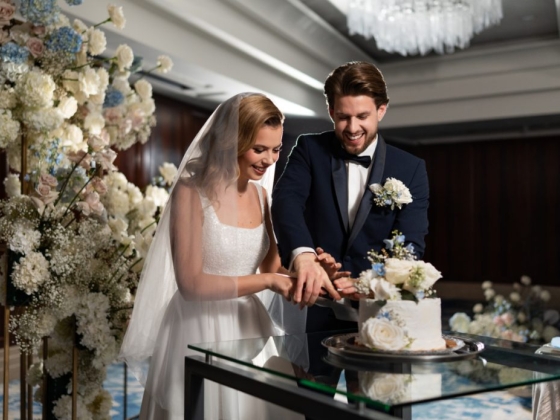 Newlyweds joyfully slice their wedding cake.