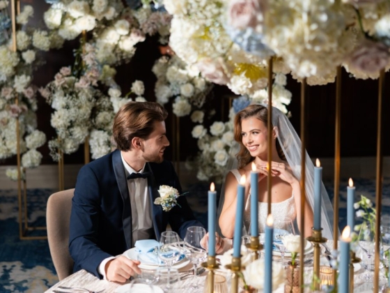 A bride and groom share a moment surrounded by floral decor.