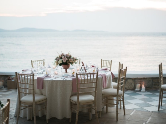 Romantic table setting by the ocean at sunset.