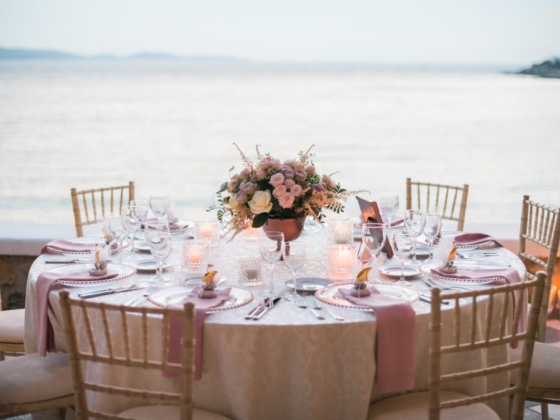 Romantic table setting by the water at sunset.