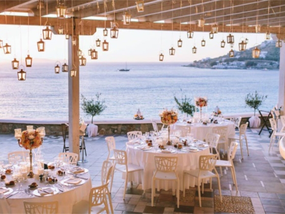 Elegant tables with flowers overlooking the ocean.