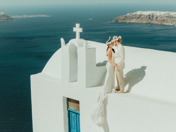 A romantic moment captured on a cliffside in Santorini.