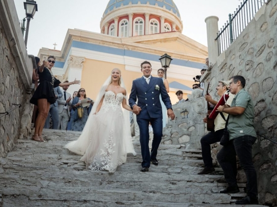Joyful newlyweds greeted by family and musicians.