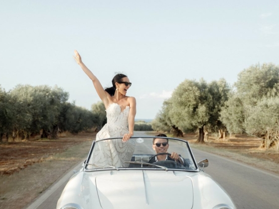 Joyful ride in a convertible amidst olive groves.