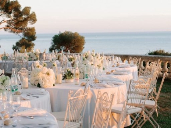 Beautifully arranged tables with floral centerpieces and string lights.
