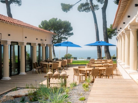 A scenic terrace with tables overlooking the sea.