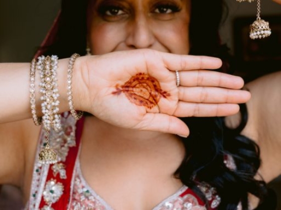 A bride proudly displays her henna art and jewelry.
