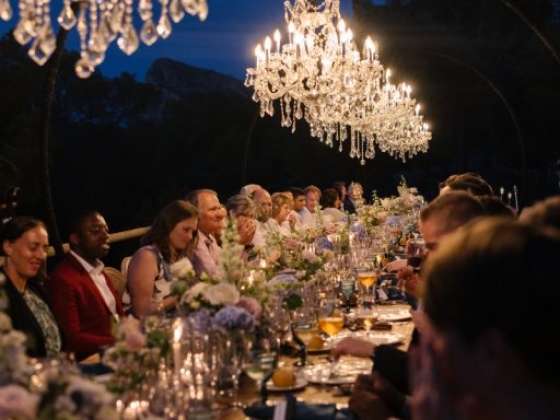 Guests enjoy a beautifully set table at dusk.