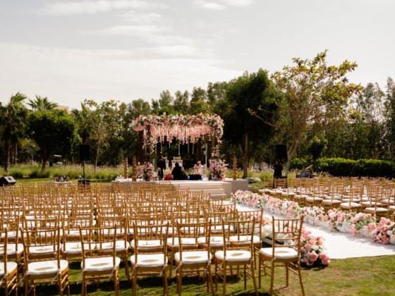 Elegant ceremony space with rows of chairs and floral arch.