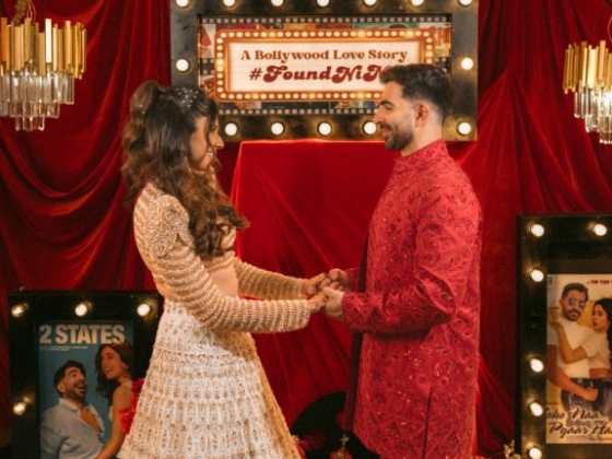 A happy couple embraces in festive attire.
