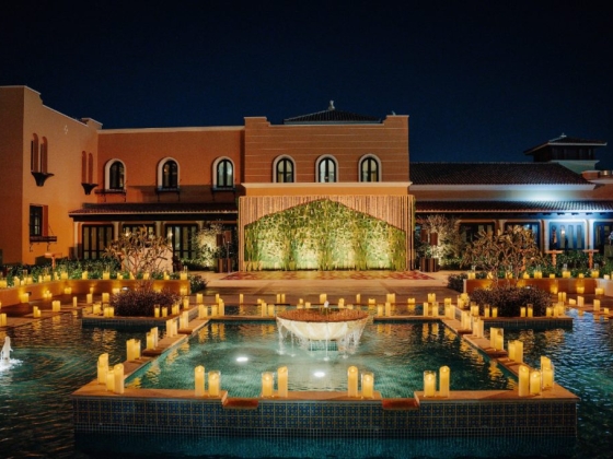 Elegant venue with illuminated water and greenery at night.