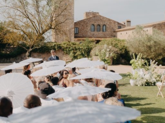 Guests seated at a wedding ceremony in a garden setting.
