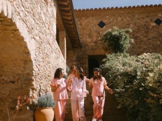 Women enjoying a sunny day at a rustic stone house
