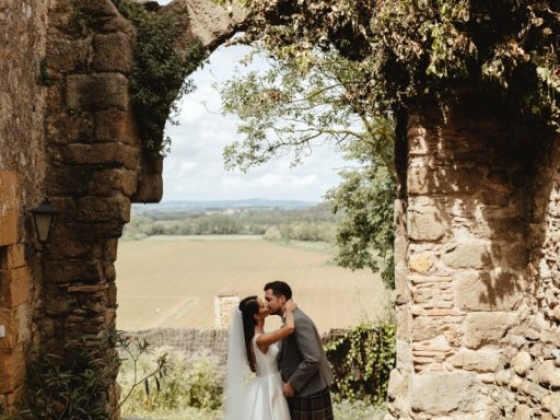 A couple shares a romantic kiss in a scenic outdoor setting.