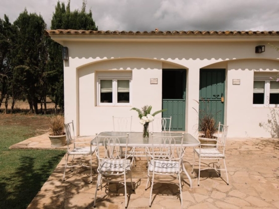 A table with chairs set against a white facade.