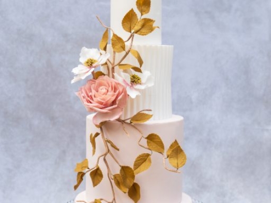 Beautiful cake adorned with roses and leaves.