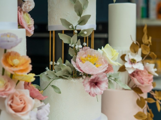 Elegant cakes adorned with vibrant pastel flowers.