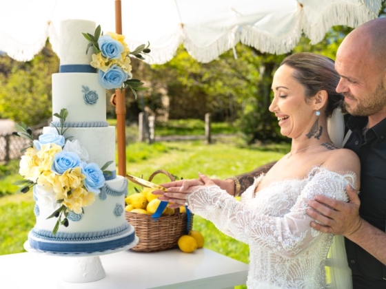 A joyful couple celebrates with a cake at their wedding.