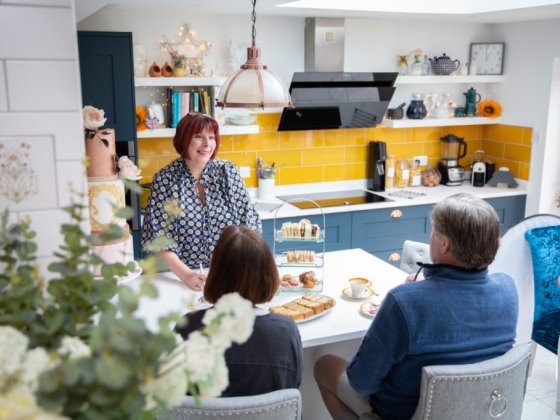 A cheerful gathering with pastries and tea in a bright kitchen.