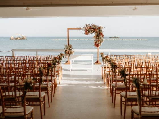 A beautiful seaside wedding setup with rows of chairs.