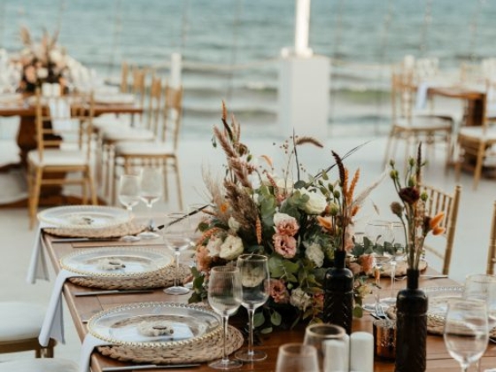 Beautiful tables arranged by the ocean for a special event.