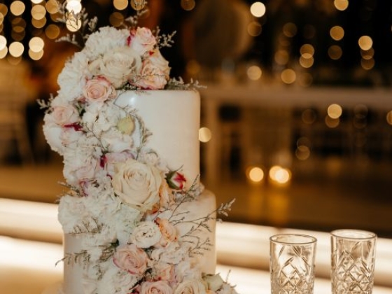 A beautifully decorated cake with floral accents and twinkling lights.
