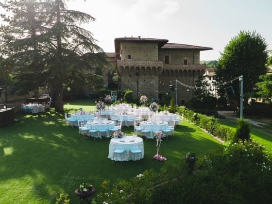 Elegant tables set up in a lush garden for a celebration.