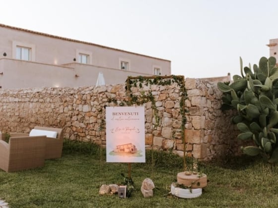 Elegant welcome display near stone wall and greenery.