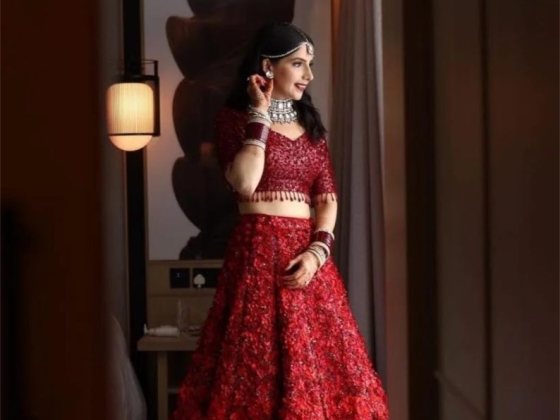 Elegant woman posing in a stunning red outfit indoors