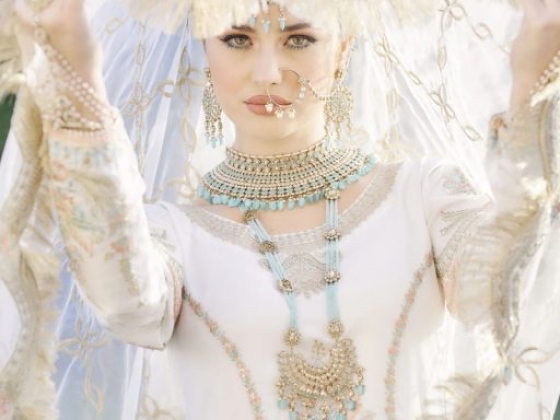 Woman in traditional bridal attire with elaborate jewelry.