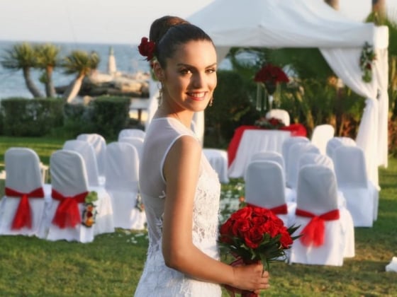 A smiling bride stands ready for her wedding.