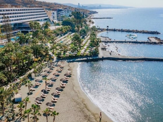 Aerial view of a beachfront hotel and sun loungers.