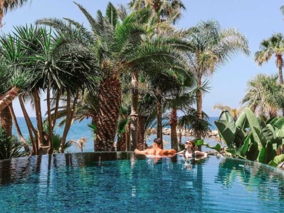 Two people relaxing by a luxurious infinity pool.