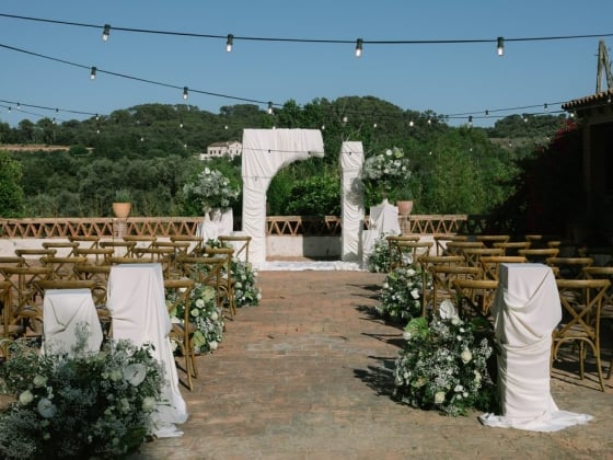 An elegant space for a wedding with chairs and floral arrangements.