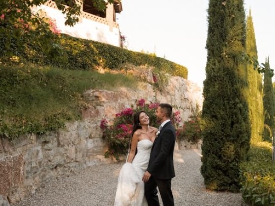 Newlyweds share a joyful moment in a lush garden setting.