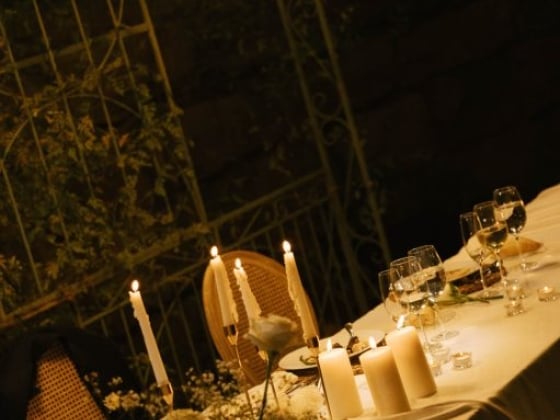 A beautifully arranged dinner table illuminated by soft candlelight.