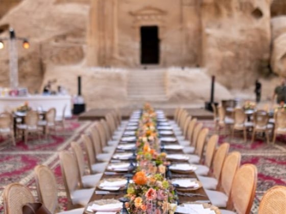Long table set for a formal meal in a stunning location.