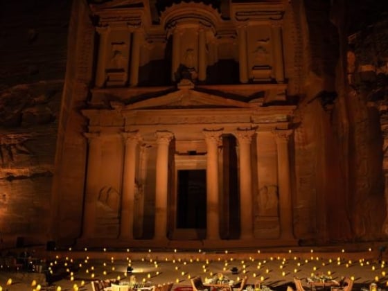 A scenic dining area under the illuminated Petra treasury.