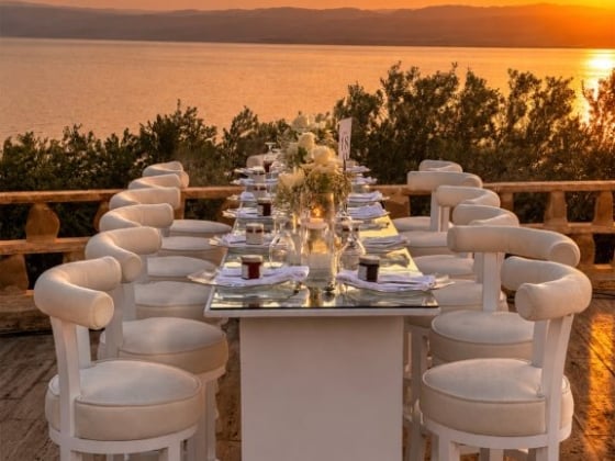 Elegant table setting with sunset view over the water.