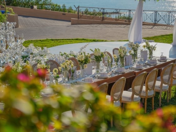 Beautifully arranged table for an outdoor event near water.