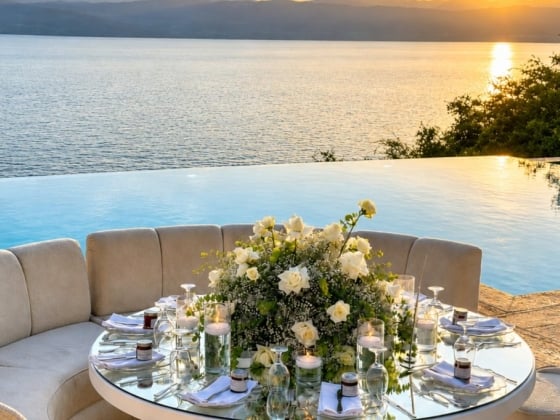 Romantic table setting overlooking a serene lake and sunset.